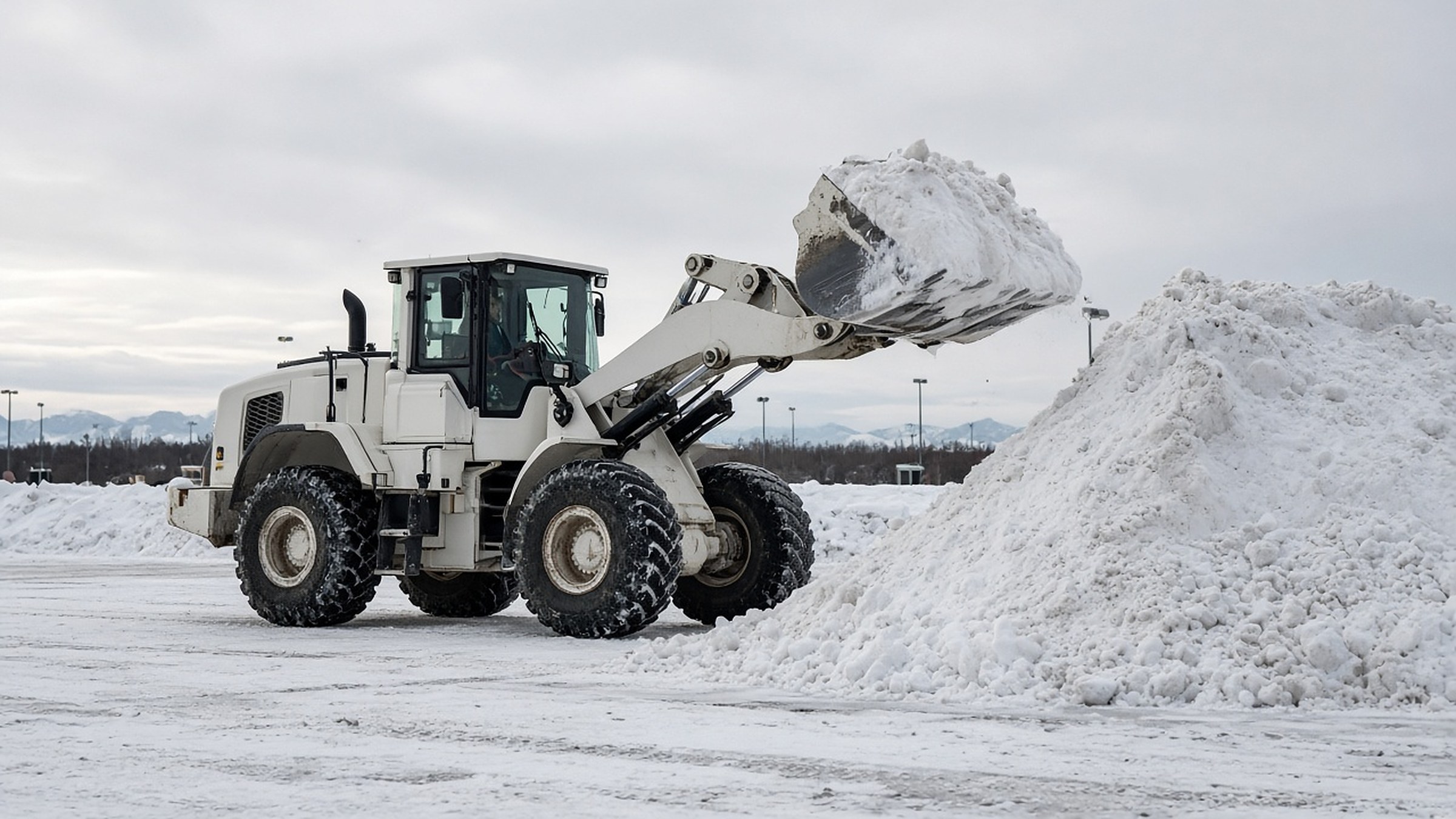 Loader stacking snow in a commercial parking lot